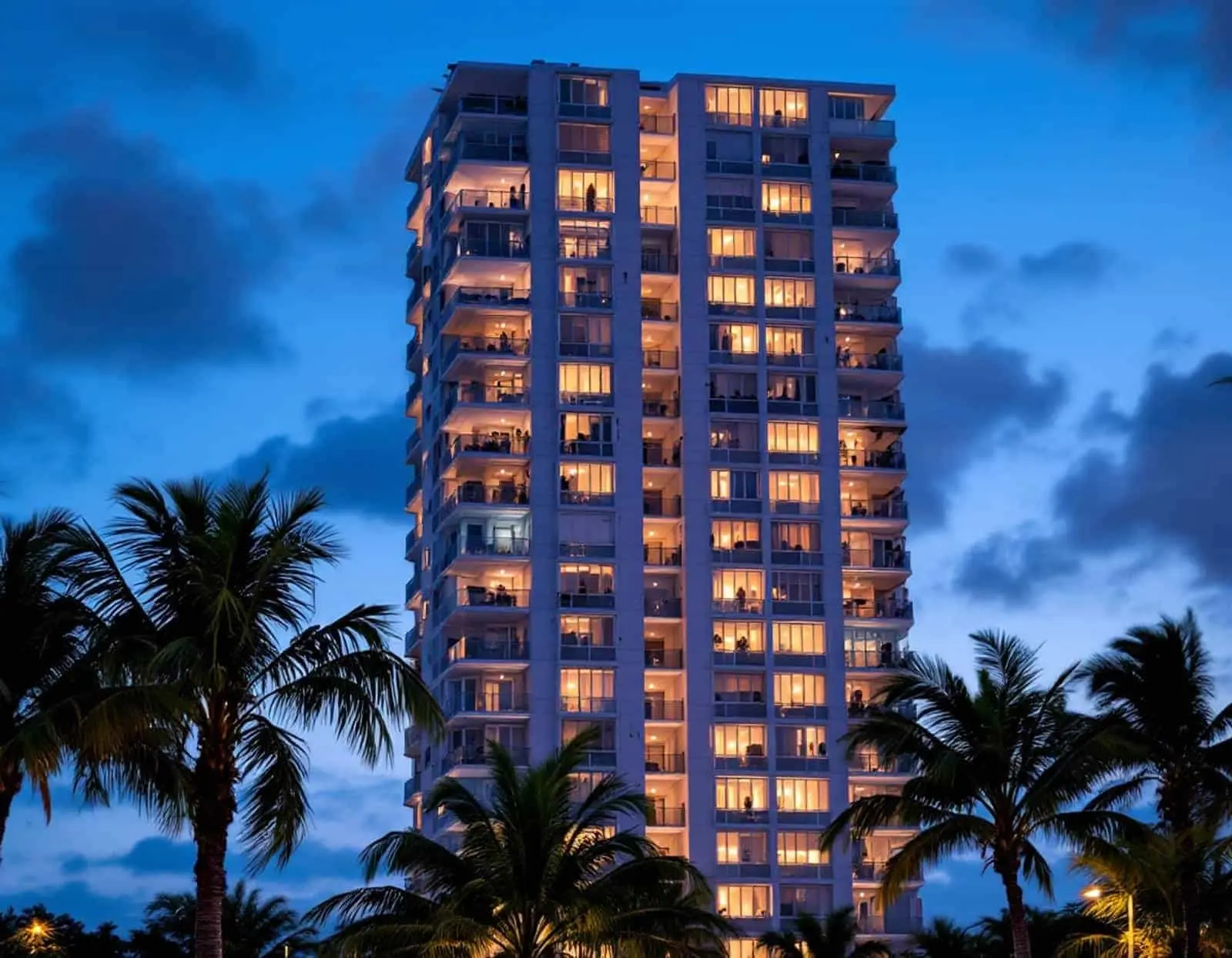 Low-rise South Florida condo and townhome buildings along a canal, palm trees in the foreground